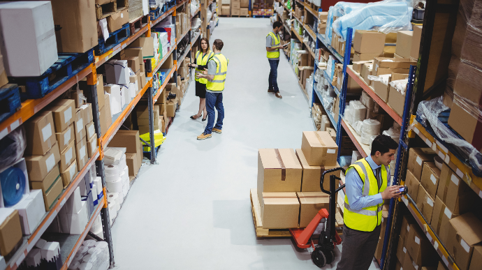 People in high vis vests working in a warehouse